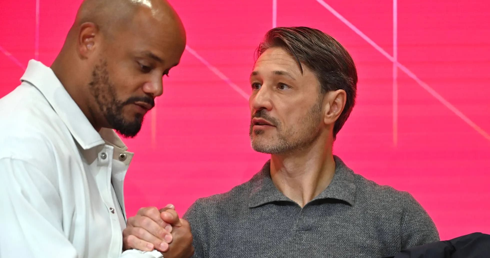 Two men shaking hands at a press event