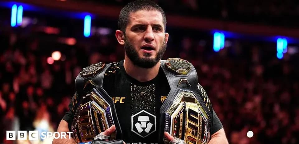 UFC fighter holding two championship belts