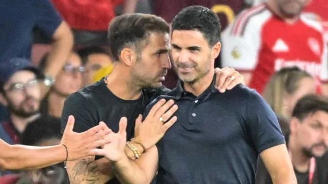 Two men conversing during a football match
