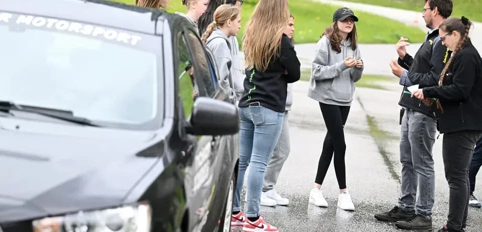 Group discussing on the roadside near a car