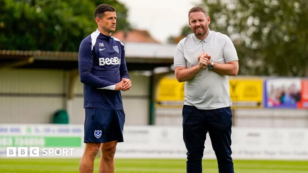 Two coaches discussing on training pitch