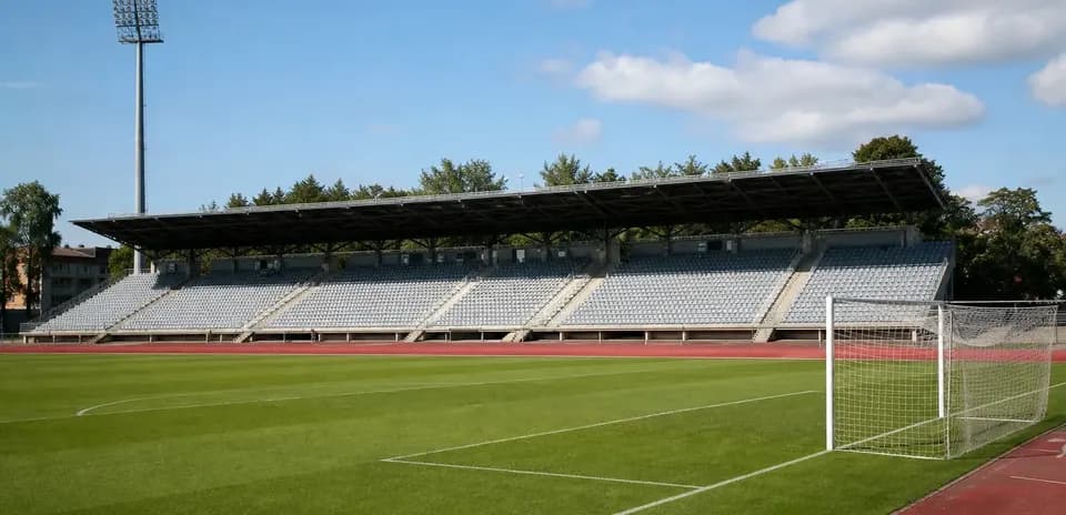 Bo'sh futbol stadionining qoldiq o'rindiqlari va darvoza