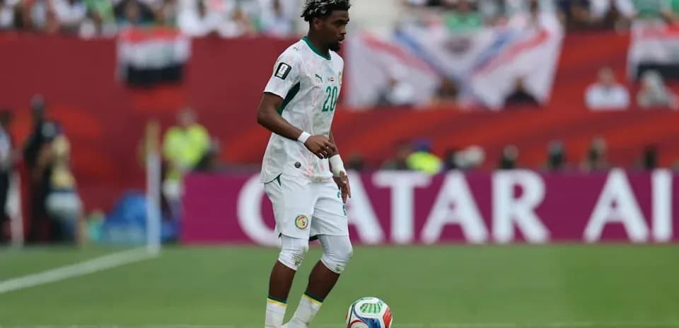 Futbolchi to'p bilan maydonda yurmoqda