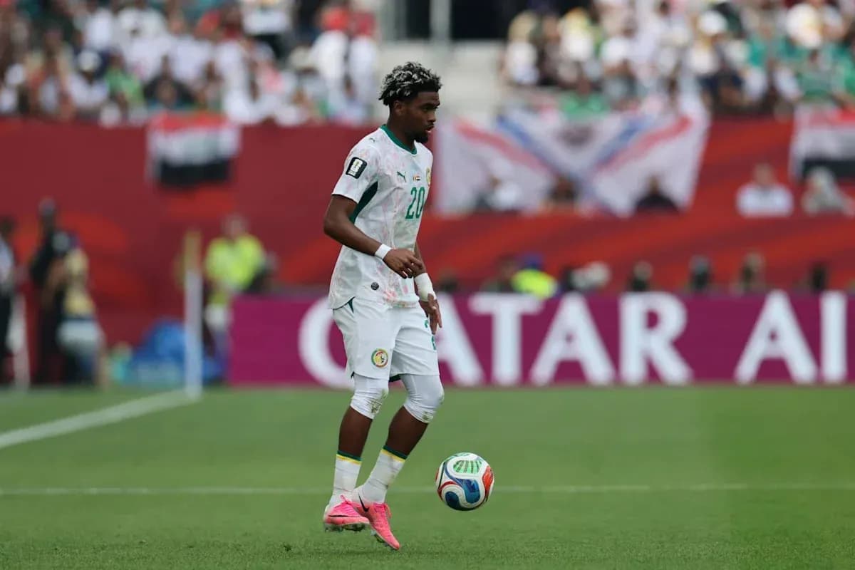 Futbolchi to'p bilan maydonda yurmoqda