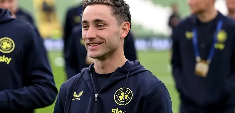 Futbolchi maydonda jamoa a'zolari bilan suhbatlashmoqda