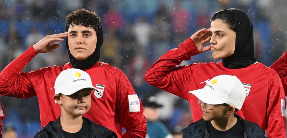 Female players saluting during national anthem ceremony