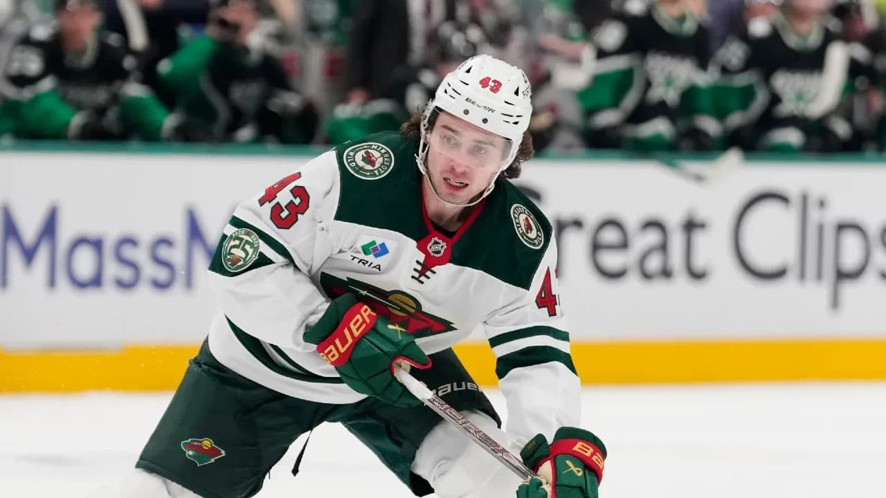 Hockey player skating with puck on ice rink