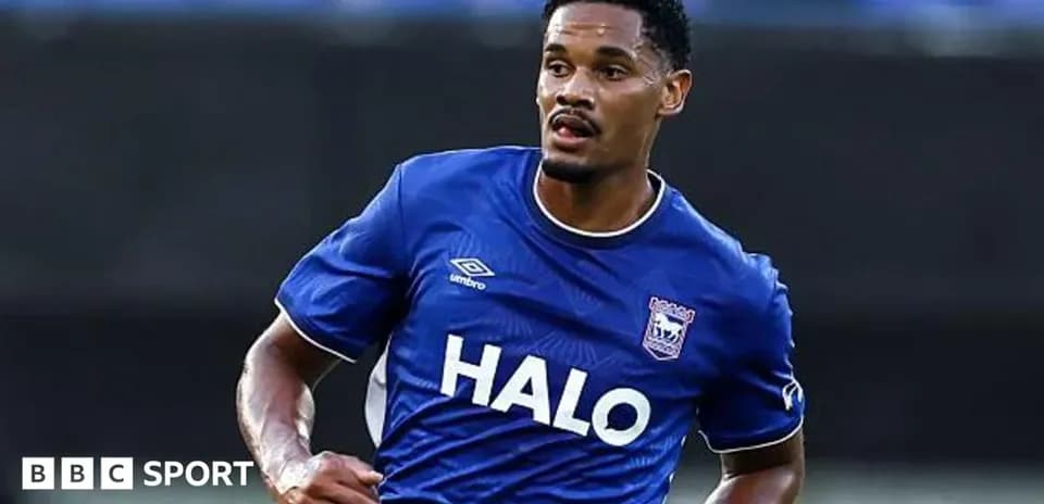 Futbolchi maydonda harakatlanayotgan ko'k forma kiygan