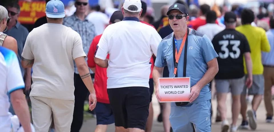 Fans walking while one holds World Cup ticket sign
