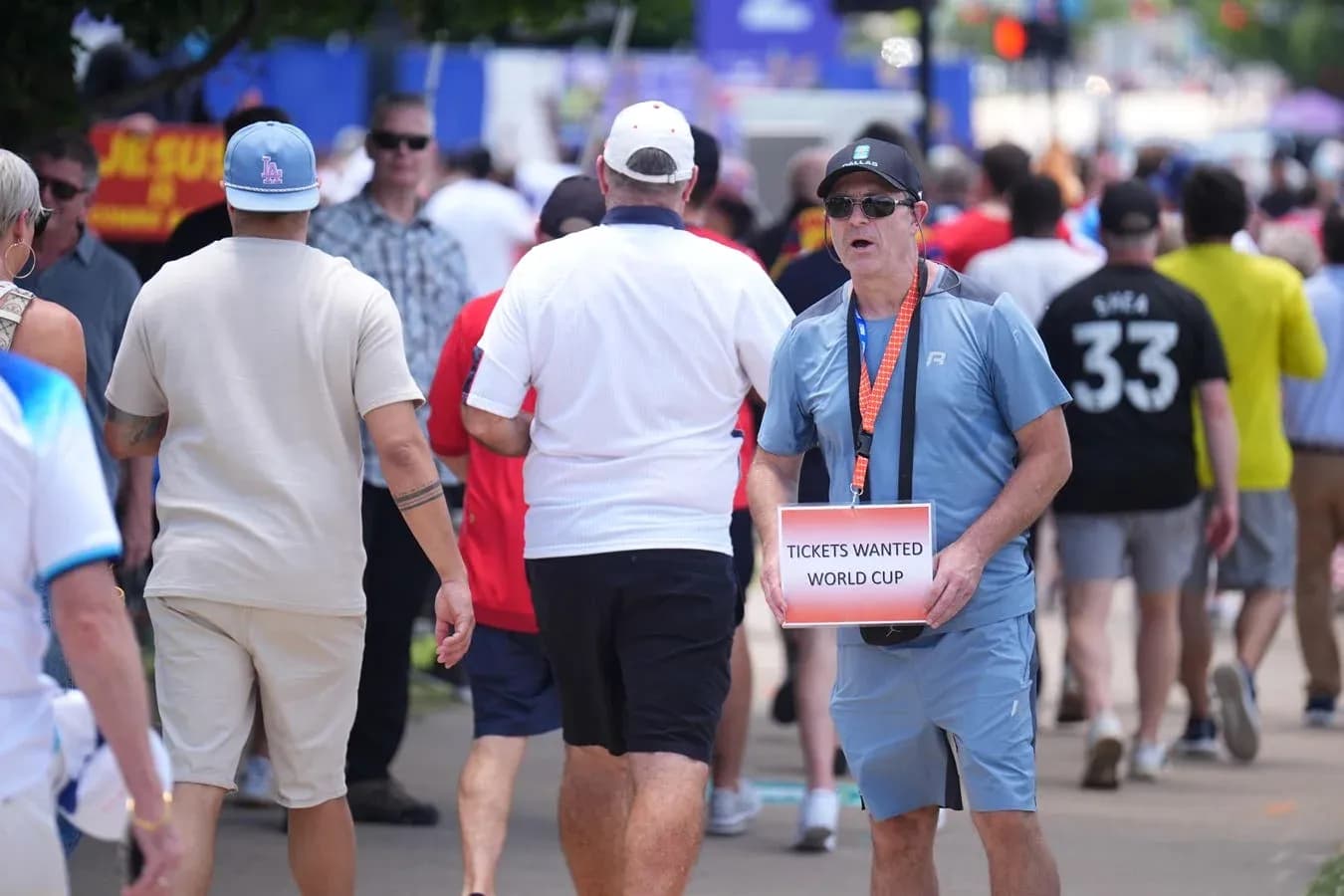 Fans walking while one holds World Cup ticket sign