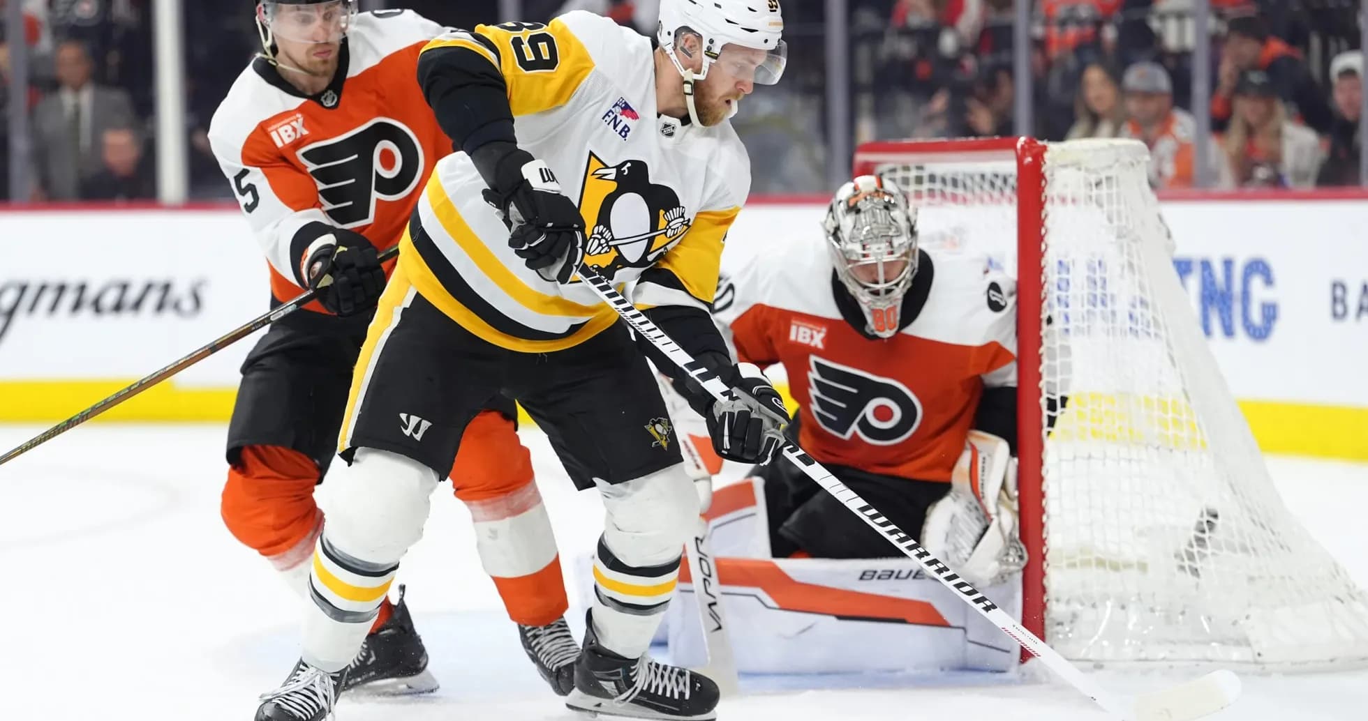 Pittsburgh Penguins player battling for puck against Flyers