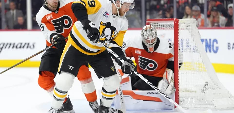 Pittsburgh Penguins player battling for puck against Flyers