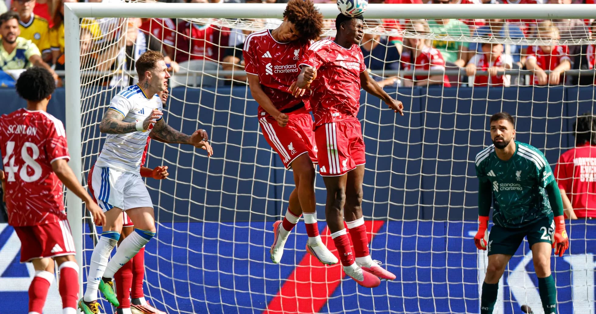 Liverpool players jumping for a header in match