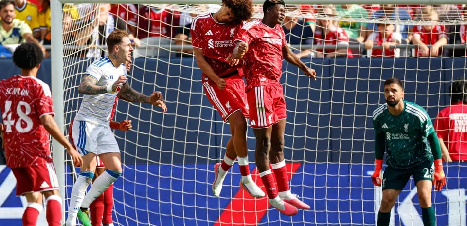 Liverpool players jumping for a header in match