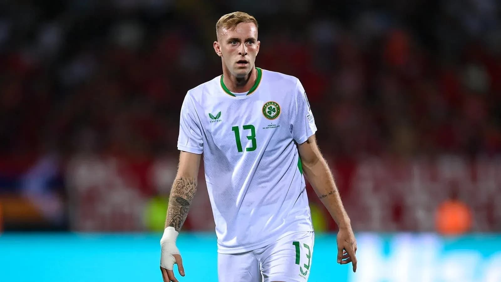 Futbolchi maydonda harakatda, oq forma kiygan