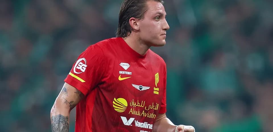 Futbolchi qizil forma bilan maydonda harakatda