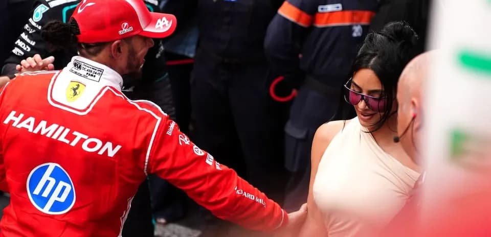 Formula 1 driver interacting with a woman in paddock