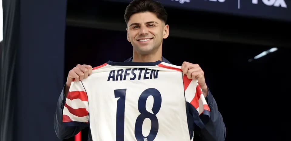 Futbolchi ARFSTEN 18 raqamli formani ko'rsatmoqda