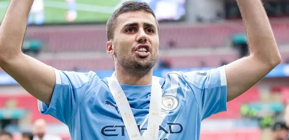 Futbolchi kubokni ko'tarib turgan paytda
