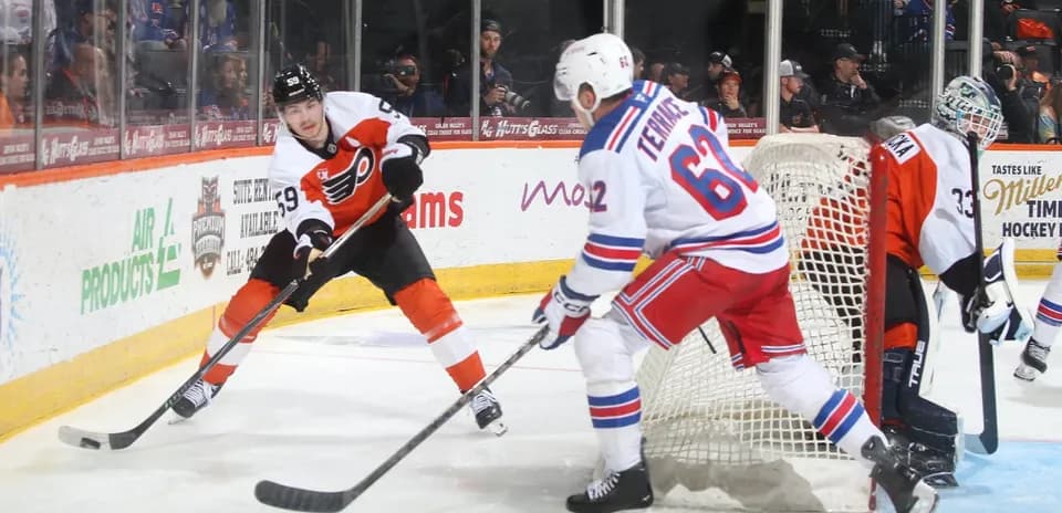 Flyers player skates with puck near Rangers goal
