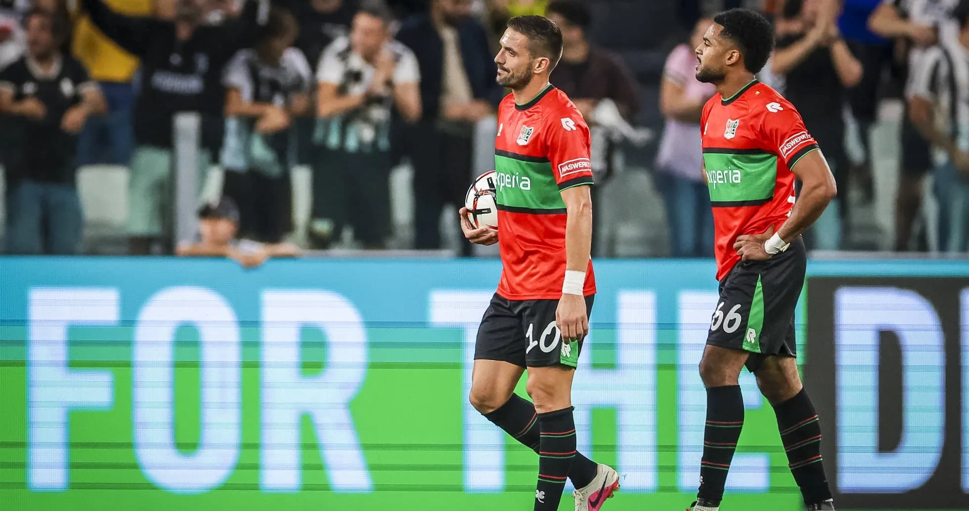 Ikkita futbolchi maydonda to'p bilan yurmoqda