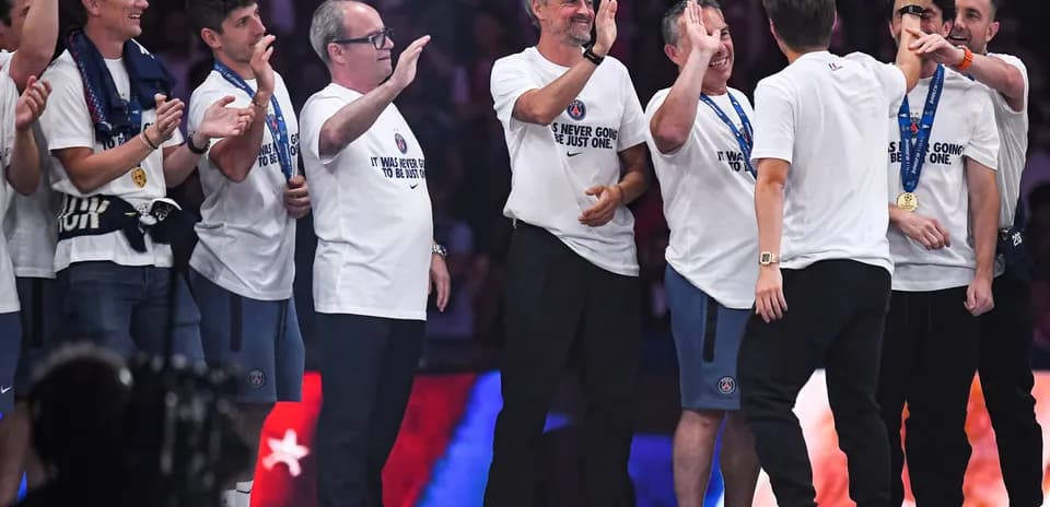 Coaches and staff celebrating on stage after victory