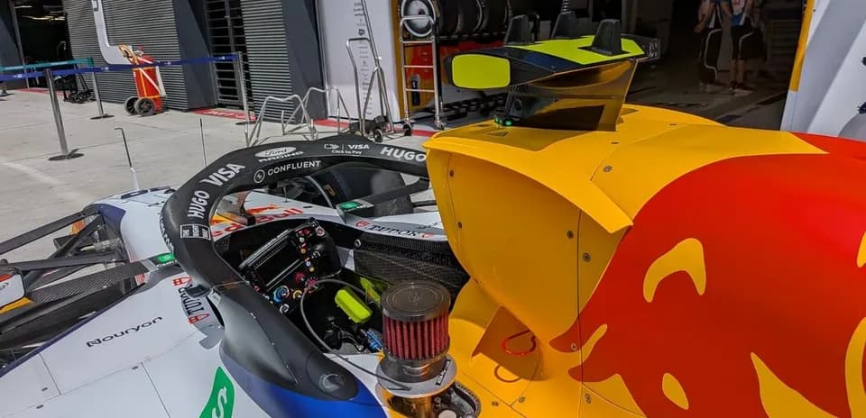 F1 car in the pit lane with team members