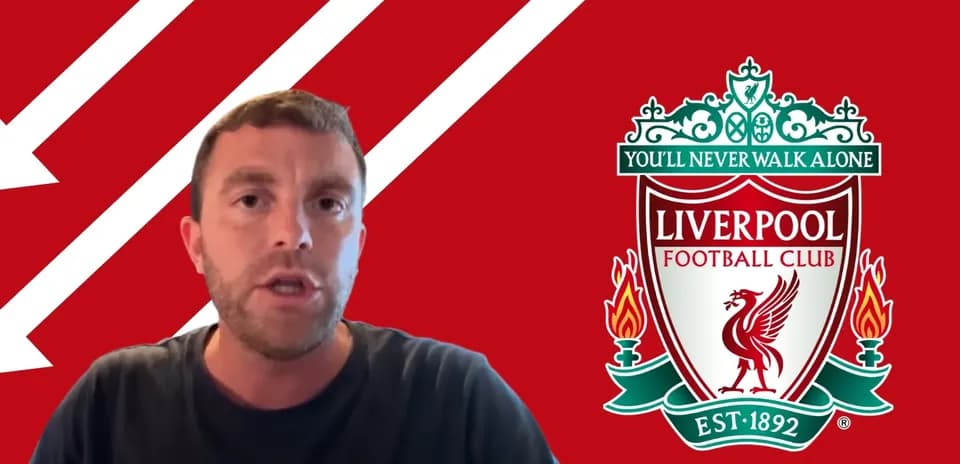 Man speaking in front of Liverpool FC logo