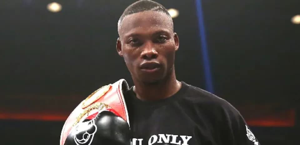 Boxer holding championship belt in ring