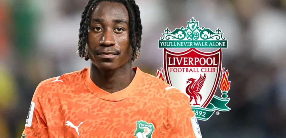 Goalkeeper in orange kit with Liverpool logo background