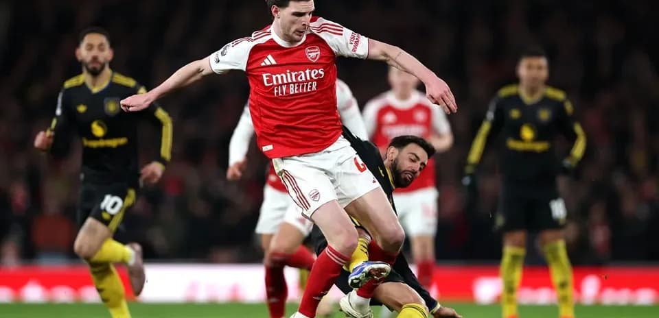 Arsenal player challenging opponent for the ball