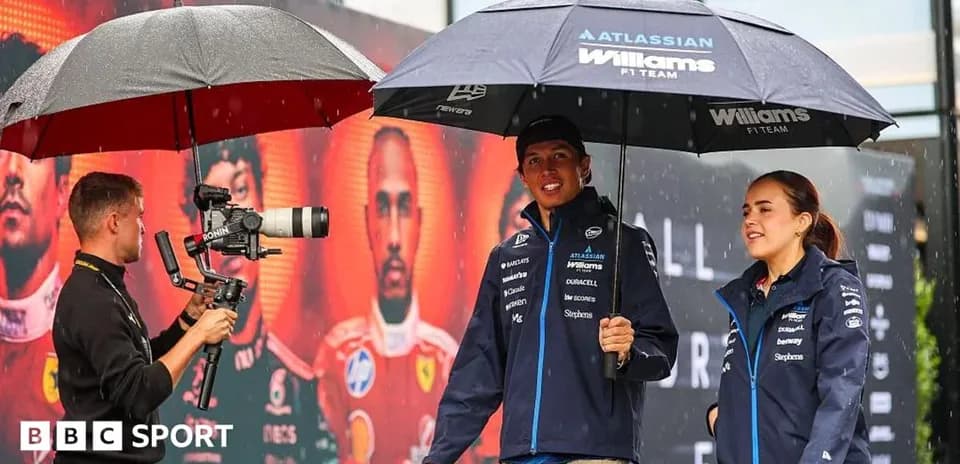 F1 drivers under umbrellas during rainy event