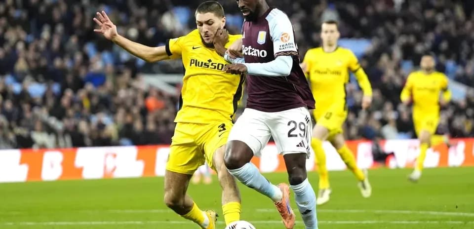 Aston Villa player dribbling past opponent during match