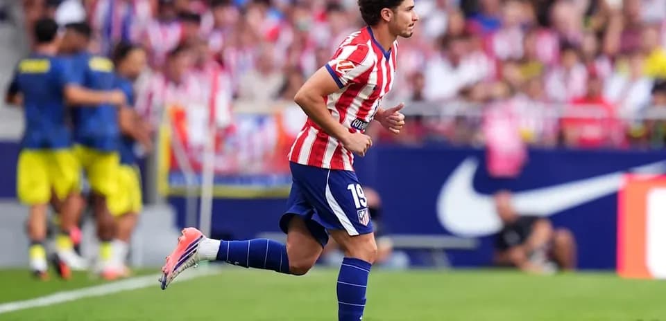 Futbolchi maydonda yugurayotgan, Atletico Madrid formasi