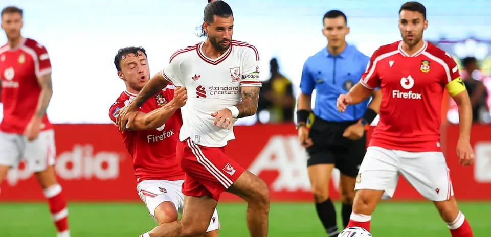 Futbolchilar to'p uchun kurashmoqda, orqa fonda hakam
