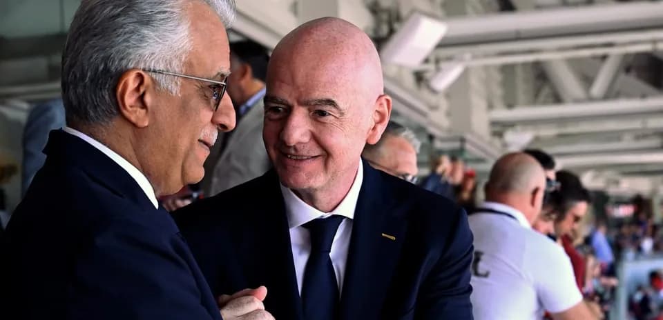 Two officials conversing in a crowded venue
