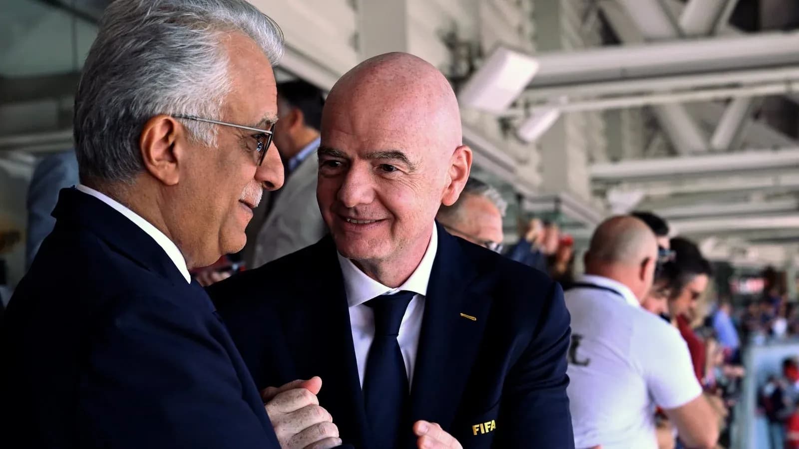 Two officials conversing in a crowded venue