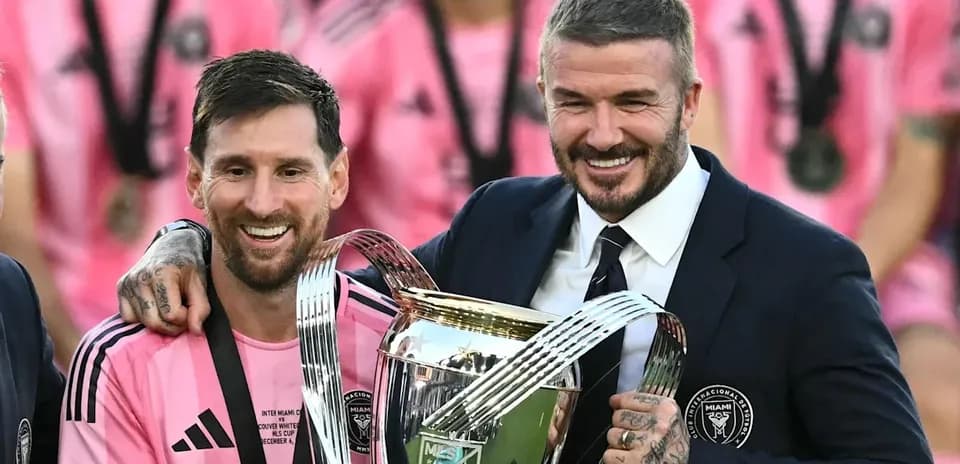 Messi and Beckham celebrating with trophy after match