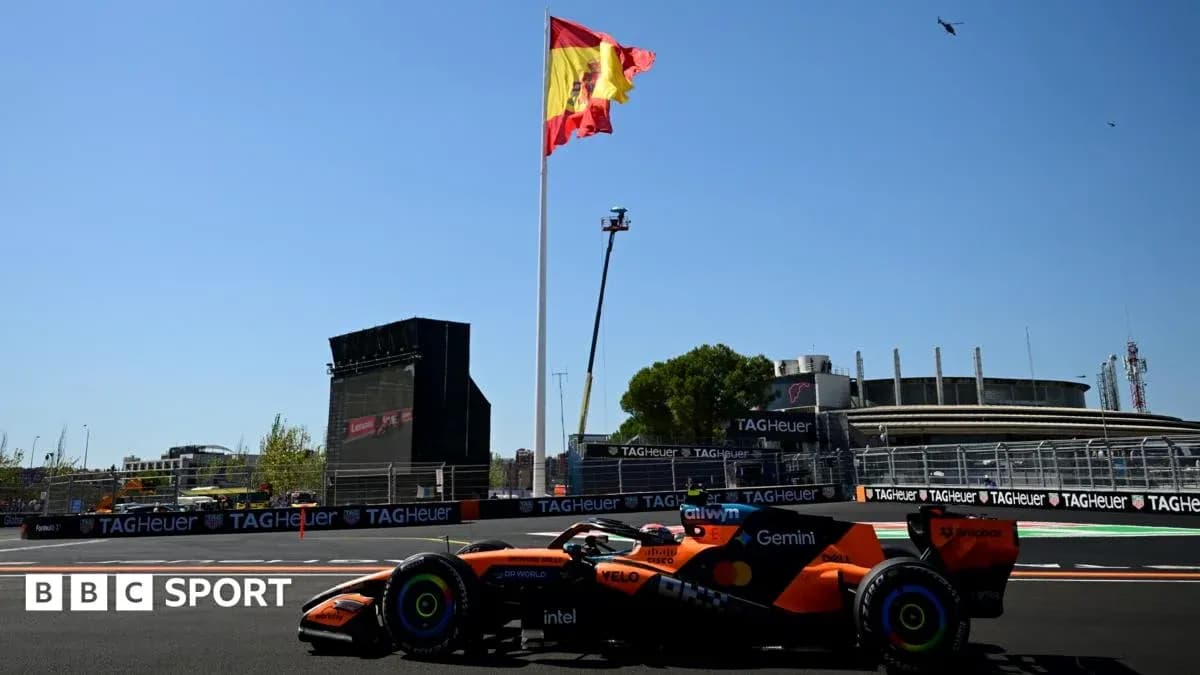 Formula 1 car passing under Spanish flag at circuit
