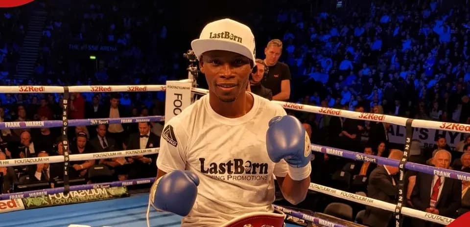 Boxer posing with championship belt in ring