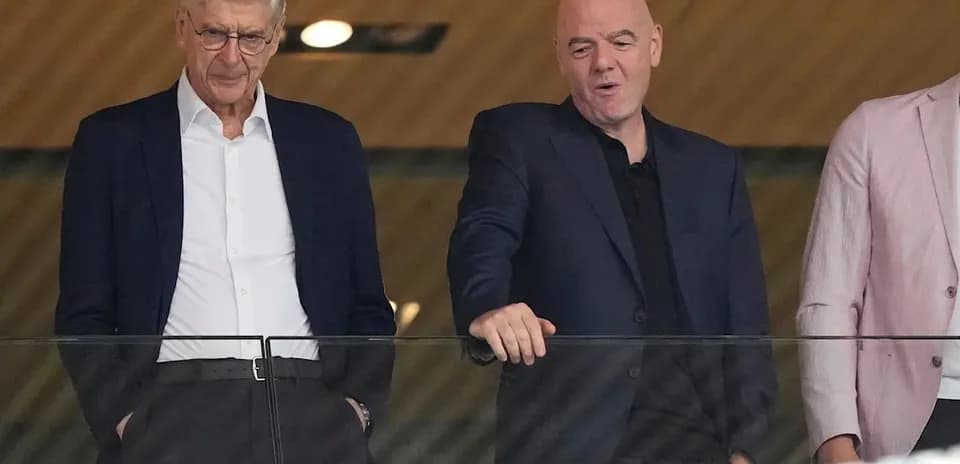 Two men in suits observing an event together