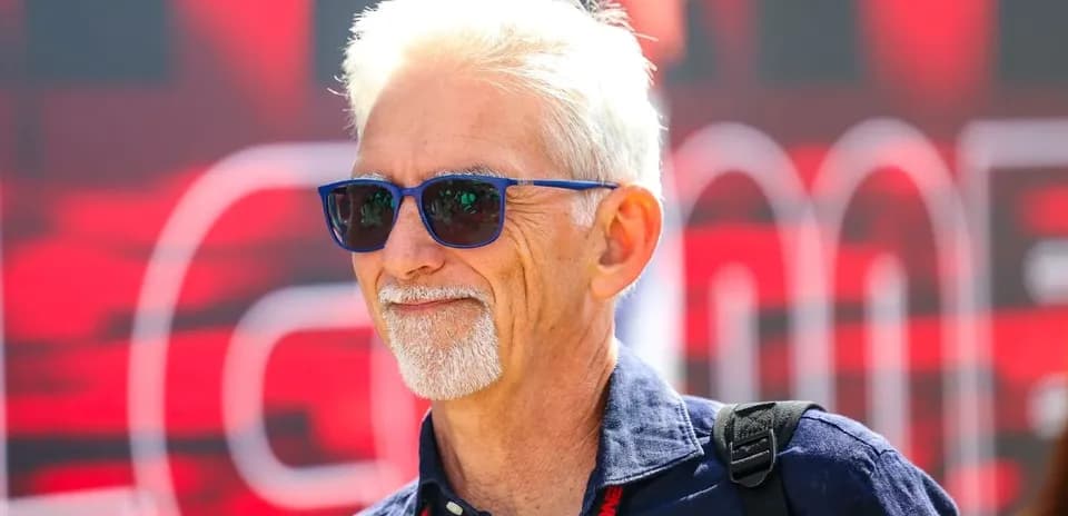 Man with sunglasses smiling at event backdrop