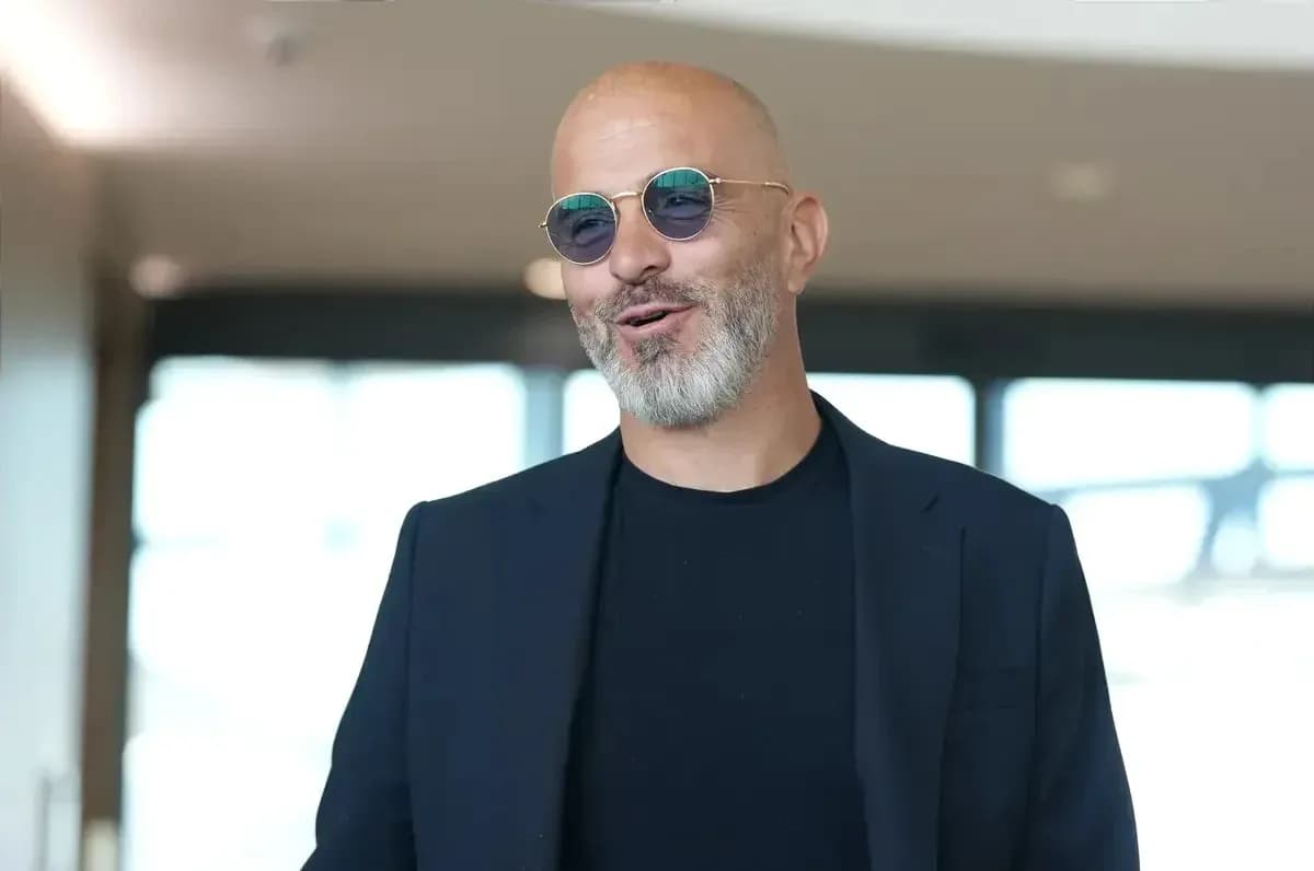 Man in sunglasses smiling in indoor setting