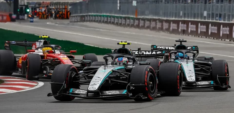 Mercedes and Ferrari cars racing closely on track