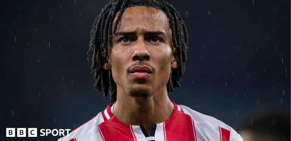 Futbolchi Brentford formasida yomg'ir ostida turibdi