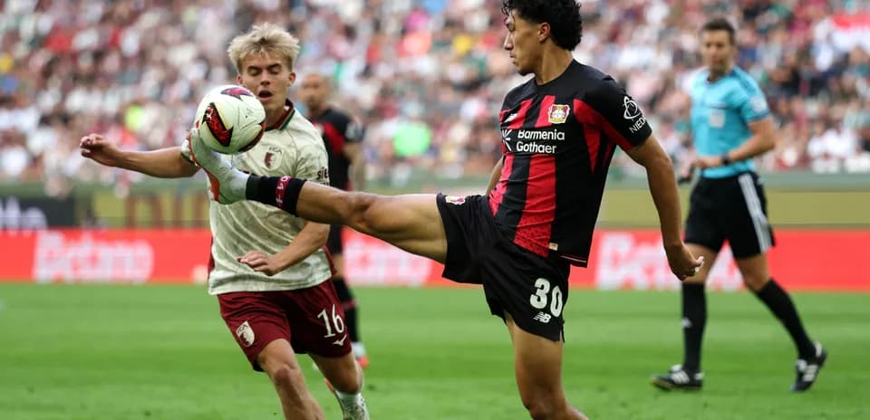Bayer Leverkusen player kicking ball against opponent