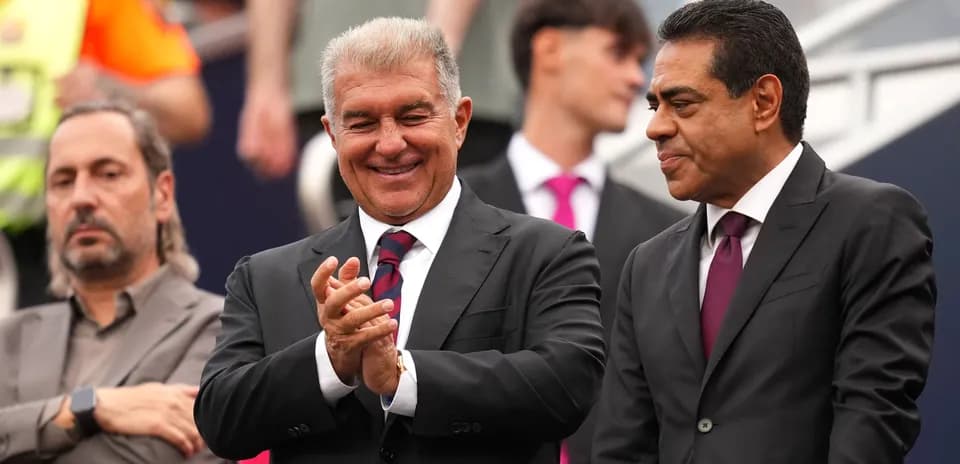 Three men in suits at a sports event