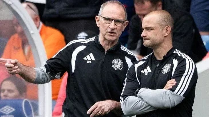 Two coaches discussing strategy on the sidelines