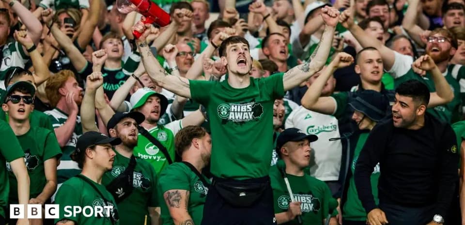 Fans cheering in green shirts at a match