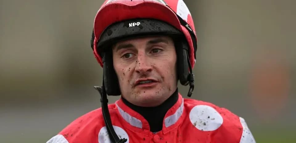 Jockey wearing red and white silks with helmet